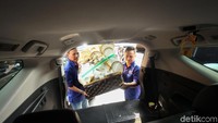 Para pedagang mengangkat parcel ke kendaraan pembeli.