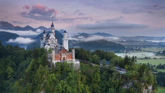Hohenschwangau, Germany - August 10, 2015: view of Neuschwanstein Castle on august 10th near Hohenschwangau, Germany during foggy summer twilight.