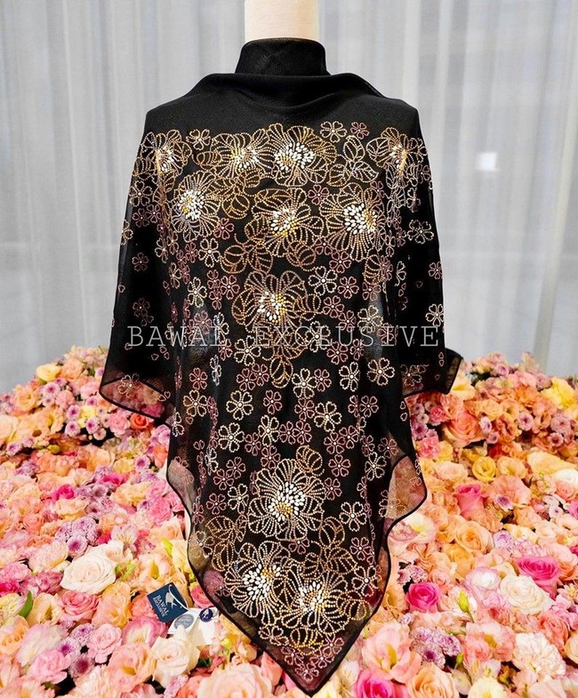 Seperti inilah kerudung bertabur Swarovski seharga Rp 172 juta. Kerudung tersebut dihiasi ribuan Swarovski yang berlisensi asli dari perusahaan kristal asal Austria itu. Tudung istimewa ini sudah pasti merupakan tudung hasil kolaborasi antara kami bersama jenama kristal antarabangsa, Swarovski. Bukan sahaja jenama kami merupakan jenama mewah hijab Swarovski yang terbesar di dunia. Kami juga merupakan syarikat Bumiputra yang menjadi antara pemborong terbesar kristal Swarovski di dunia, tulis Bawal Exclusive lagi di Facebook. Foto: Facebook Bawal Exclusive