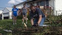 Warga memotong pohon yang tumbang akibat diterjang tornado. Matthew Hatcher/Getty Images.