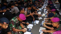 Anggota TNI dan polisi menikmati menu berbuka yang disajikan.