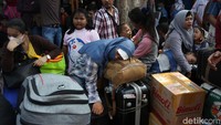 Penumpang kelelahan dan tertidur di atas tas miliknya.