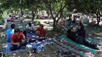Para pemudik beristirahat di taman yang ada di rest area.