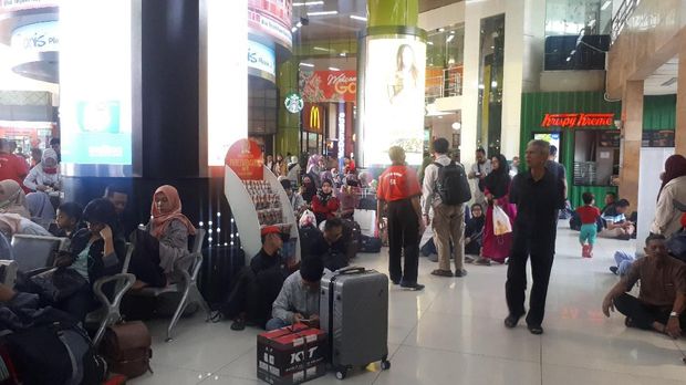 Sejumlah penumpang tampak lesehan menanti jadwal keberangkatan kereta api.