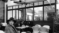 Berlibur ke Paris, Gao pasang pose keren saat menikmati secangkir kopi hangat, di salah satu kafe yang berada di sana. Foto: Instagram @godfreygao