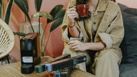Agar lebih bersemangat, Jessica memilih minum secangkir kopi di pagi hari. Slurp! Terlihat ia sedang duduk di sebuah kafe. Foto: Instagram@jscmila