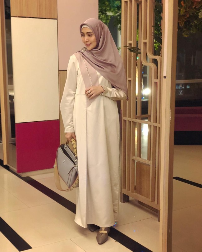 Gaya Fenita Arie berikut cocok diterapkan saat Lebaran. Gamis putih dipadukan dengan hijab dan sepatu warna terang yang senada. Sematkan bros cantik pada hijab untuk menambah sentuhan yang lebih spesial. Foto: Instagram