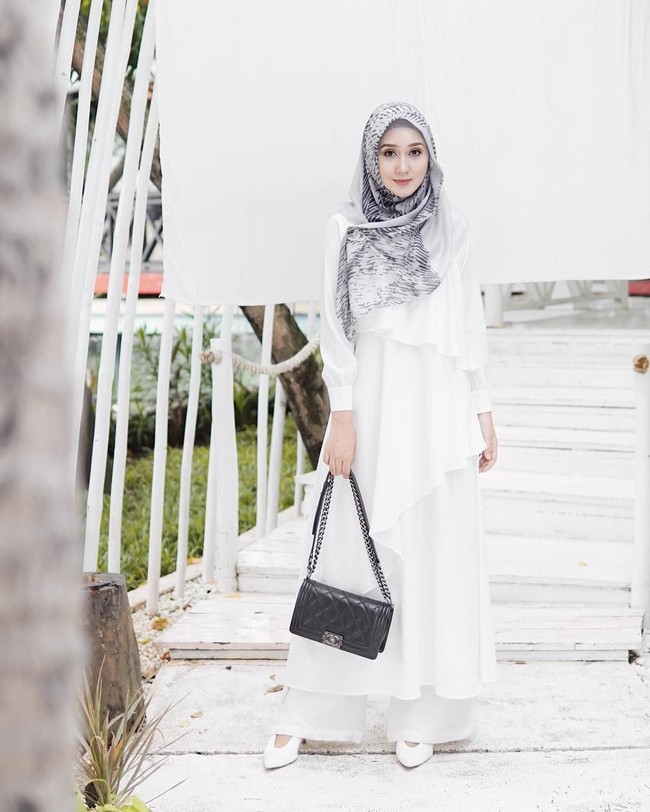 Gaya desainer Dian Pelangi juga dapat jadi inspirasi. Dian mengenakan terusan dengan aksen ruffle yang dipadukan dengan celana pallazo serba putih. Untuk kesan yang tetap calm, pilih hijab dan aksesori dengan warna monokrom saja. Foto: Instagram