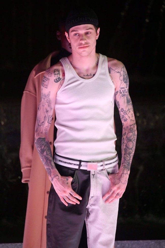 Topi baseball yang dipakai secara terbalik dan ikat pinggang putih melengkapi penampilannya. (Foto: Mike Coppola/Getty Images)