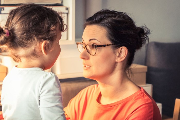 Rearview shot of a young woman and her daughter having a conversation on the porch