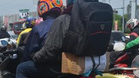 Pemudik yang lain juga ramai-ramai menuliskan sesuatu. Menuju jalan yang benar Begitu tulisan di kardus belakang pemudik bermotor ini. Foto: Sudirman Wamad