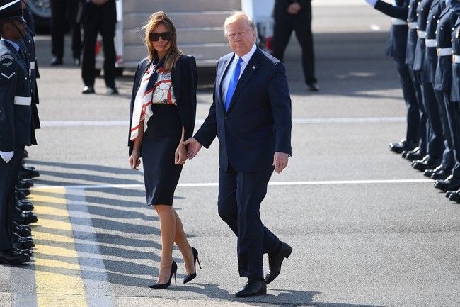 Menginjakkan kaki di Inggris, Melania Trump tampak berbalut atasan Burberry Sleeveless Archive Print Pussy-Bow Blouse seharga US$ 820 (Rp 11 jutaan) dan  Michael Kors Stretch-Wool Blazer seharga US$ 1.395 atau Rp 20 juta. Roknya juga Michael Kors yang bernilai $650. Sementara sepatunya Christian Louboutin seri So Kate Pumps yang harganya sekitar US$ 695 atau Rp 9,8 juta. (Foto: Getty Images)