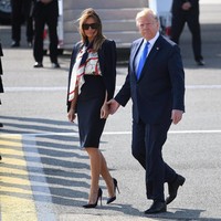 Menginjakkan kaki di Inggris, Melania Trump tampak berbalut atasan Burberry Sleeveless Archive Print Pussy-Bow Blouse seharga US$ 820 (Rp 11 jutaan) dan  Michael Kors Stretch-Wool Blazer seharga US$ 1.395 atau Rp 20 juta. Roknya juga Michael Kors yang bernilai $650. Sementara sepatunya Christian Louboutin seri So Kate Pumps yang harganya sekitar US$ 695 atau Rp 9,8 juta. (Foto: Getty Images)