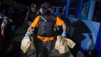 Polisi mengamankan barang bukti saat melakukan penggeledahan dini hari tadi.