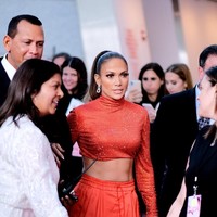 Tidak ketinggalan sepasang platform heels merah yang menopang kaki jenjangnya dan clutch senada ikut menemani penampilan J-Lo di karpet merah. (Foto: Getty Images)