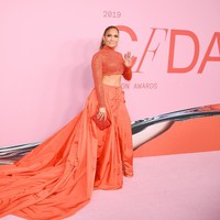 Menemani penampilannya, sebuah gaun oranye terang dari Ralph Lauren. Gaun tersebut terdiri dari turtle neck cropped top yang mengekspos perut ratanya dan rok dengan ekor panjang nan dramatis. J-Lo pun terlihat seksi sekaligus menawan di saat bersamaan. (Foto: Getty Images)