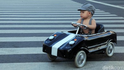 Lucu, Begini Gaya Balita Nyetir Mobil dan Mandi di Jalan Thamrin