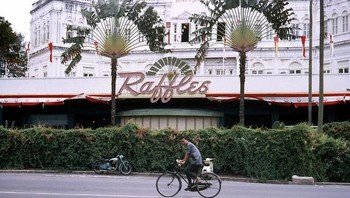 Salah satu bangunan peninggalan Inggris yang jadi latar belakang orang bersepeda di jalan raya. Foto: Vintages