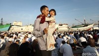 Warga datang ke lokasi salat Idul Fitri dengan mengajak anak-anaknya.
