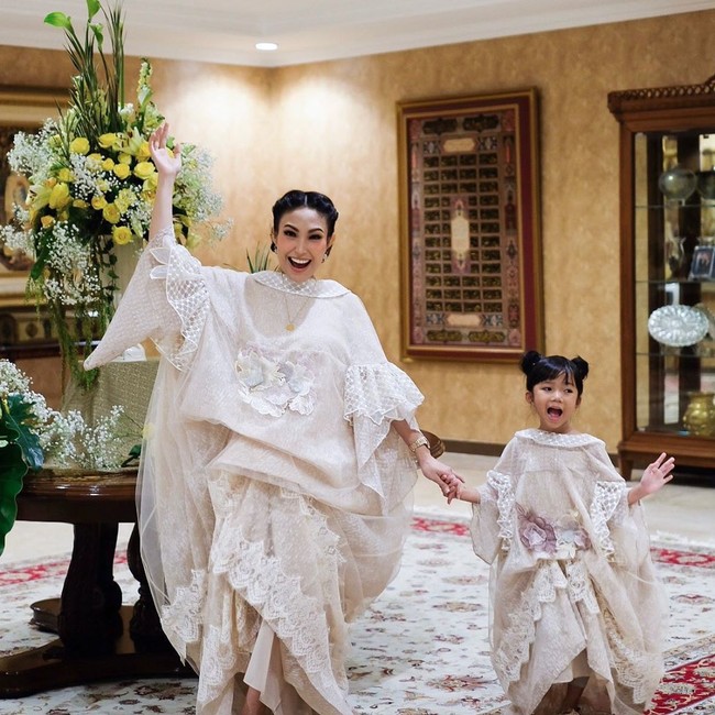 Tak cuma Dian Sastrowardoyo, presenter Ayu Dewi juga memakai busana kembar dengan putrinya. Keduanya kompak dalam balutan gaun bergaya baju bodo dengan rok bertumpuk rancangan Rama Dauhan. (Foto: Instagram/@mrsayudewi)