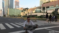Ada yang sedang membaca koran di tengah jalan dengan latar belakang Bundaran HI. Ada juga yang membawa kain pel seolah sedang membersihkan jalanan. (Foto: Rolando/detikcom)
