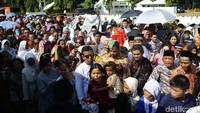 Sebagian warga memakai payung agar terhindar dari sinar terik matahari.