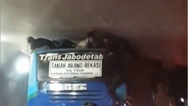 Bocah terjepit karena naik di atas bus.