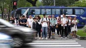 Para karyawan ramai masuk ke kantor pada pagi hari. Foto: Reuters