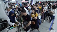 Antrean penumpang yang akan memasuki stasiun mengular panjang.
