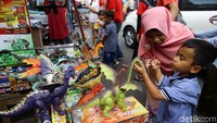 Seorang anak mengecek mainan yang akan dibelinya.