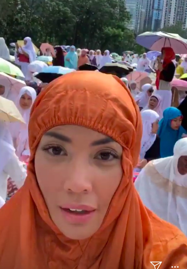 Penyanyi Shanty yang tinggal di Hong Kong melaksanakan salat Idul Fitri di kawasan Victoria Park. Tidak seperti artis lainnya yang memilih mukena putih, Shanty tampak memakai mukena berwarna cokelat. (Foto: Instagram)