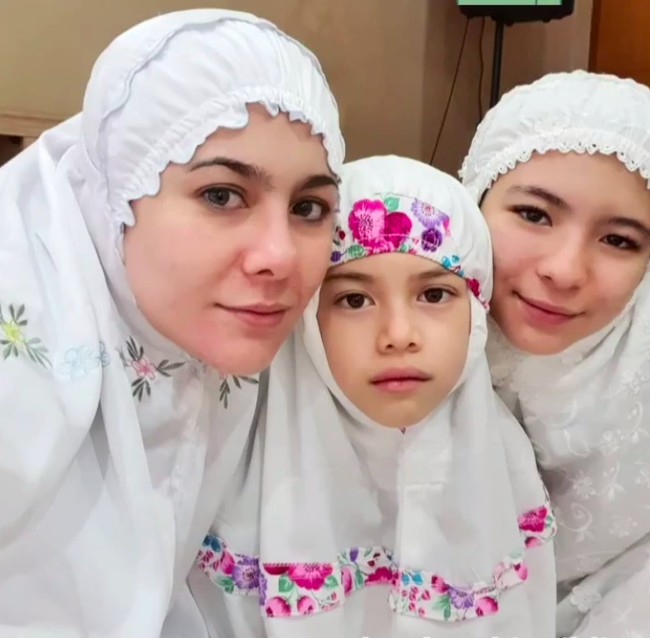 Aktris Wulan Guritno tampil cantik memakai mukena putih dengan detail bunga saat salat Ied. Wulan melaksanakan salah Idul Fitri bersama dua putrinya Shalom Razade dan London Abigail. (Foto: Instagram)