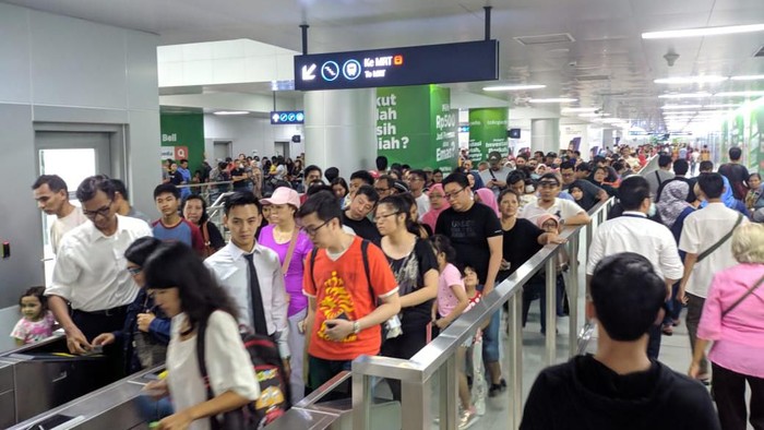 Pengguna MRT antre di mesin tap kartu.