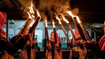 Sekumpulan bocah lain memegang obor, bersiap menjalani pawai. (Foto: Ulet Ifansasti/Getty Images)