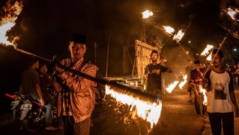 Aksi memutar-mutar obor yang tersulut api di kedua sisi mampu menghasilkan efek foto dramatis. (Foto: Ulet Ifansasti/Getty Images)
