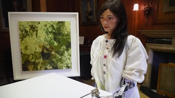 Ai-Da berpose dengan pensil di tangan mekaniknya, hendak membuat sketsa. (Foto: Matthew Stock/Reuters)
