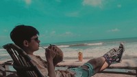 Need a vacation, tulis Rayn. Pemain film Dear Nathan ini terlihat tengah meminum air kelapa di pinggir pantai. Asyiknya! Foto: Instagram raynwijaya26