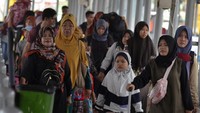 Satu per satu pemudik berjalan kaki menuju kapal.