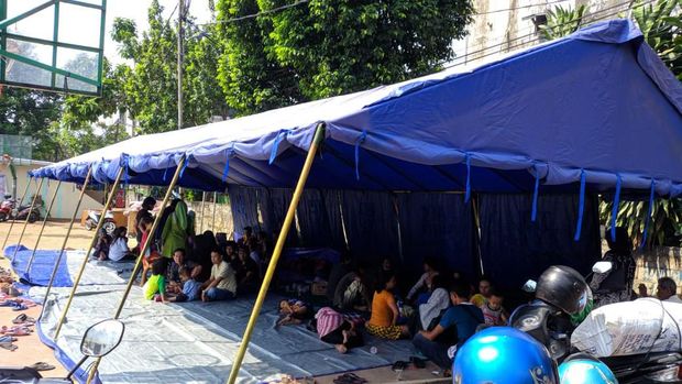Korban mengungsi di tenda darurat.