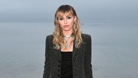Miley Cyrus tampil cantik dengan setelan jins hitam belel dengan blazer berwarna senada. Foto: Miley Cyrus dan Liam Hemsworth (Getty Images/Neilson Barnard)