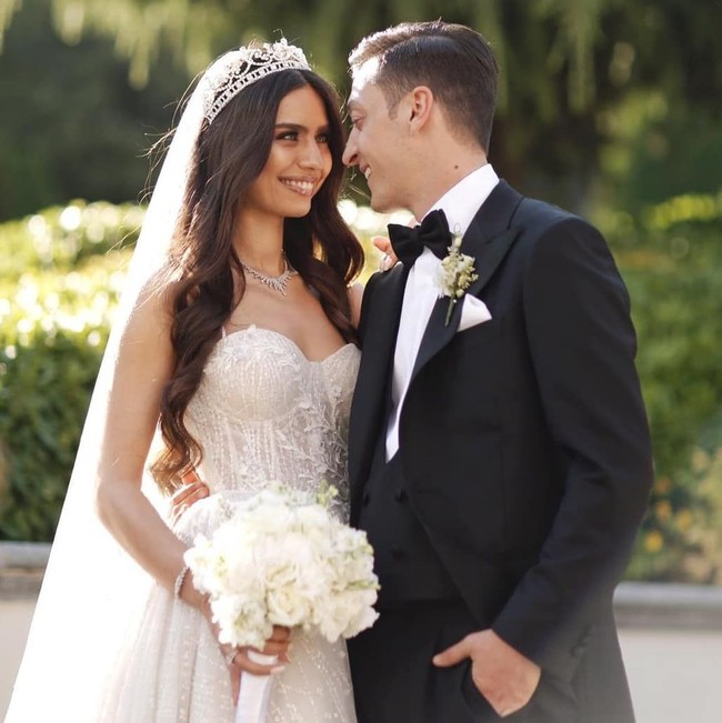 Inilah momen mesra Amine Gulse dan pesepakbola Arsenal, Mesut Ozil, setelah mereka remi menikah pada Jumat (7/6/2019) di Turki. Amine tampil memesona dalam balutan gaun putih dengan tali kecil di bahunya. Rambut panjangnya yang digerai tampak dihiasi veil putih panjang dan tiara yang membuatnya bak princess. (Foto: Ist.)