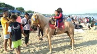 Ada pula wisatawan yang menyewa kuda untuk berkeliling di sekitar pantai tersebut.