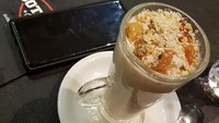 Perpaduan cream kelapa dan susu cair membuat minuman ini memiliki sensasi yang unik. Masukkan ke dalam gelas, beri toping, dan sajikan dalam keadaan hangat. (Kholifatunnisa/Istimewa)