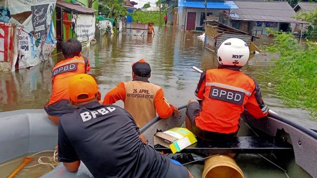 Personel BPBD menyisir kawasan permukiman dengan perahu karet.