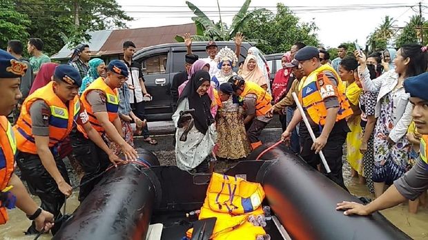 Mardiana hendak menaiki perahu karet.