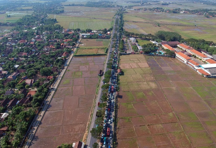 Foto udara kendaraan arus balik di Jalur Pantura, Kendal, Jawa Tengah, Senin (10/6/2019). Pada H+5 Lebaran 2019, arus balik terpantau masih ramai di jalur pantura yang bersimpangan dengan sejumlah exit tol menuju jalur pantura Jateng, sebagai imbas sudah diberlakukannya dua arah di tol Trans Jawa. ANTARA FOTO/Harviyan Perdana Putra/hp.