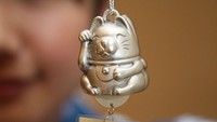 Ada pula Maneki Neko yang berwarna emas yang diyakini menjadi simbol dari kemakmuran dan mendatangkan kekayaan. Koichi Kamoshida/Getty Images.
