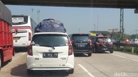 Pemudik yang tidak bisa menaruh oleh - oleh di dalam mobilnya biasanya akan menyiasatinya dengan menaruhnya di atas atap mobil.  Tapi yang ini jangan ditiru. Foto: Luthfi Anshori/detikOto