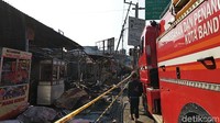 Garis polisi dipasang di sepanjang area kios-kios yang terbakar. Sejumlah masyarakat yang datang hanya bisa melihat dari balik garis polisi itu.