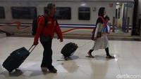 Pemudik melintasi peron saat tiba di stasiun.